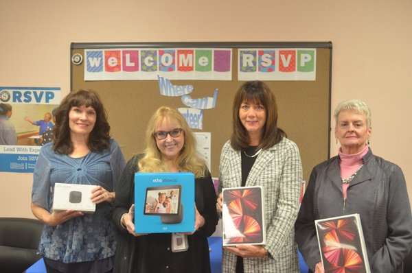Bonnie Saunders, Department of Aging supervisor of services; Cathy Mackay, Department of Aging director; Karen Niemic Buchheit, CRCF executive director; and Wendy Brand, CRCF board member and grant allocations committee member, display technology devices purchased with a CRCF Mental Wellness Fund grant.
